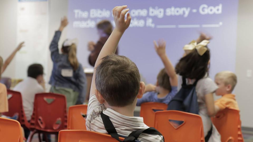 Child raising hand in Sunday school